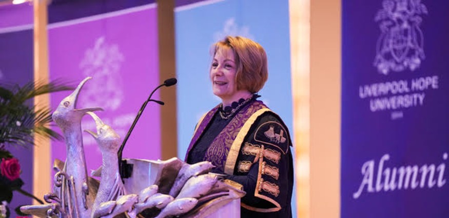 Professor Claire Ozanne addresses the congregation from a lectern at Liverpool Metropolitan Cathedral.